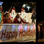 dark night sky with brightly lit holiday float in christmas parade