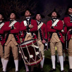 7 men in re coats and beige colonial style pants with fife and drum
