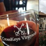 Wine glass tilted with red wine and the words CrossKeys Vineyard etched on the glass